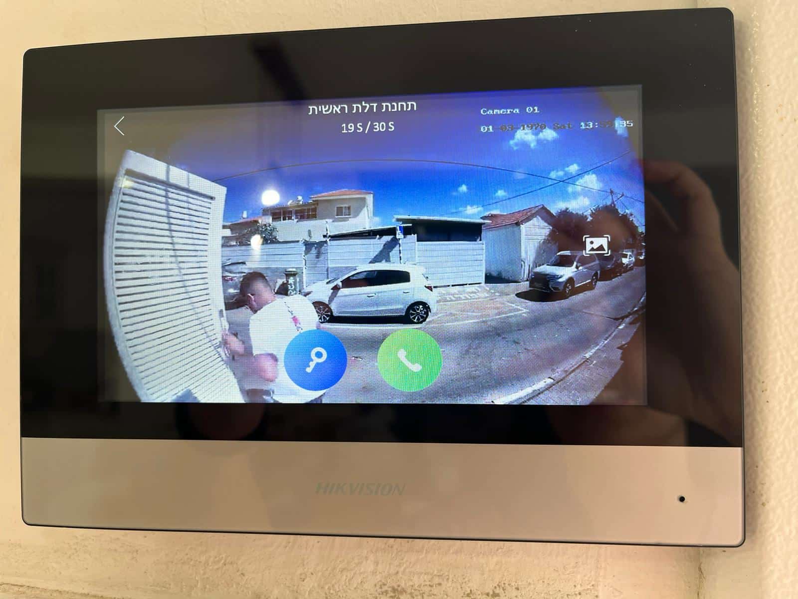 מסך אינטרקום Hikvision פנימי מציג בזמן אמת את מצלמת דלת הכניסה והחניה